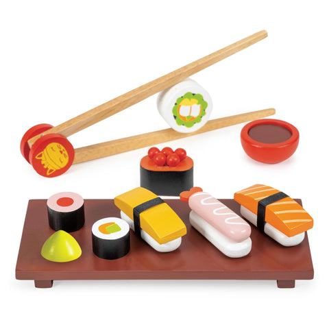Toy sushi set with chopsticks, soy sauce, and garnishes on a white background