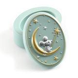 Decorative pastel green container with a mouse on a moon design on a white background