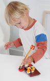 Child playing with a toy sushi set on a white surface